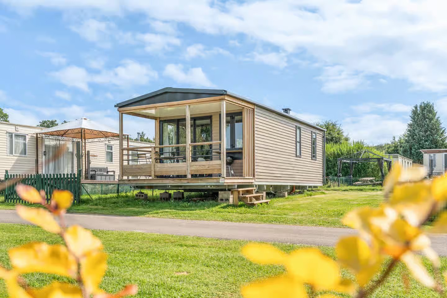Le chalet 137 et sa terrasse couverte, vus du parc