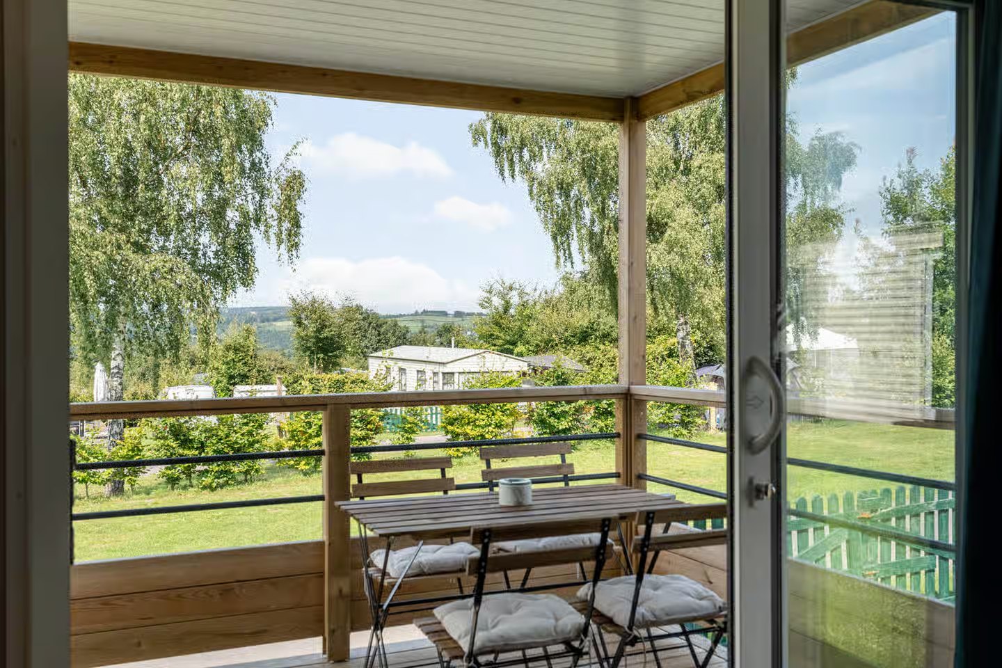 Vue depuis l'intérieur vers la terrasse et les collines